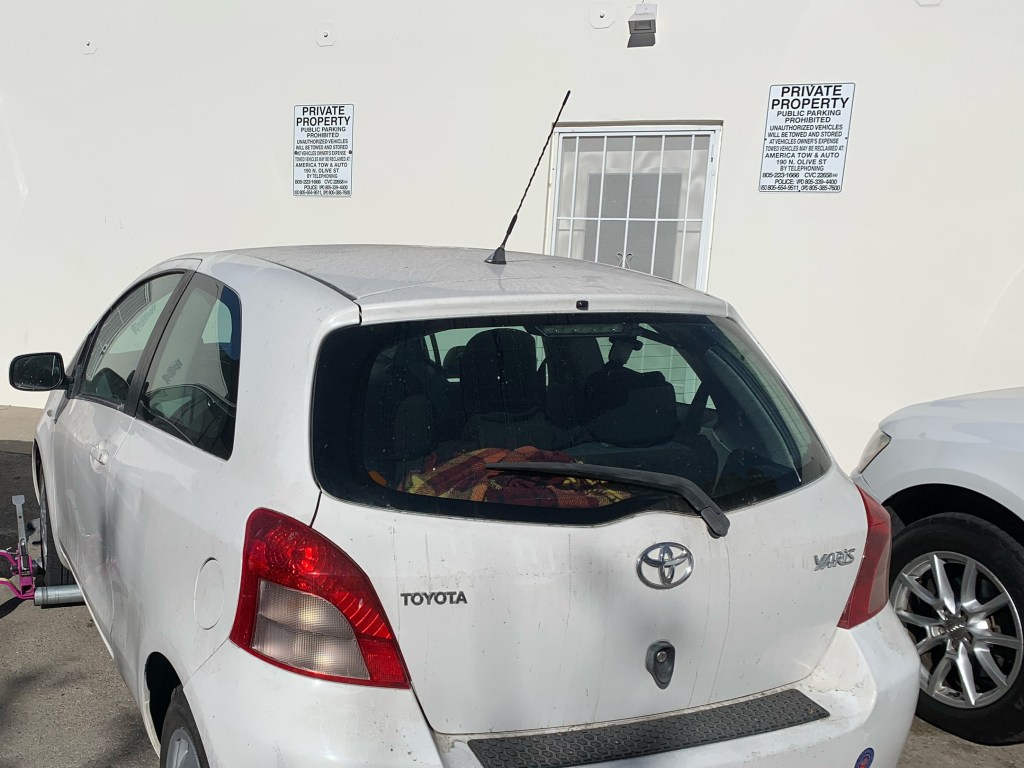 An illegally parked car getting towed off private property